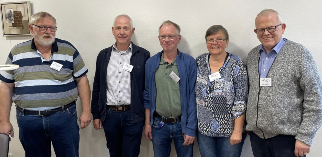Gruppe von Personen steht zusammen und lächelt in die Kamera