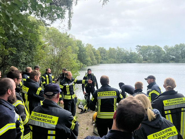 Gruppe von Feuerwehrleuten vor einem Fahrzeug